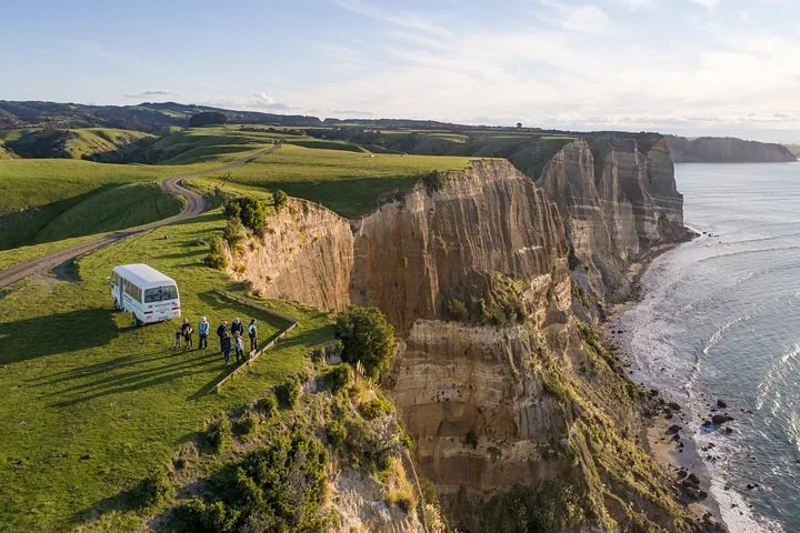 Tourgruppe und Bus auf malerischer Küstenklippe